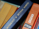 Шкаф наполнен самыми разными книгами
